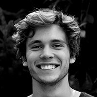 Smiling young man with curly blond hair.